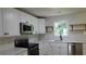 Well-lit kitchen features stainless steel appliances, open shelving, white cabinets, and subway tile backsplash at 9148 Homewood Dr, Riverdale, GA 30274