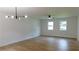 Open living room area with hardwood floors, modern light fixture, and natural light from the double windows at 9148 Homewood Dr, Riverdale, GA 30274
