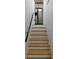 Ascending stairs with wood treads lead to a kitchen with stainless steel refrigerator at 9148 Homewood Dr, Riverdale, GA 30274