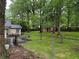 Large backyard with metal chain fence and a storage shed behind the trees at 1268 Woodland Ne Rd, Conyers, GA 30012
