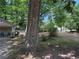 Backyard with mature trees providing plenty of shade with porch and chairs at 1268 Woodland Ne Rd, Conyers, GA 30012