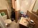 Compact bathroom with toilet, sink, shower, and floral wallpaper accents at 1268 Woodland Ne Rd, Conyers, GA 30012