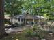 View of the exterior with brick chimney and small porch with blue chairs at 1268 Woodland Ne Rd, Conyers, GA 30012