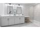 Bright bathroom featuring a double vanity with quartz countertops, stylish mirrors, and glass enclosed shower at 3334 Swallowtail Ter, Duluth, GA 30096