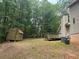 Backyard featuring a wooden shed, a deck, and lush green trees at 6649 Valley Hill Sw Dr, Mableton, GA 30126