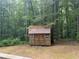 A wooden shed in the backyard, surrounded by trees and greenery at 6649 Valley Hill Sw Dr, Mableton, GA 30126