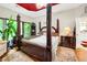 Elegant bedroom with a four-poster bed, lush plants, and ample natural light, creating a tranquil retreat at 185 Beracah Sw Walk, Atlanta, GA 30331