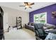 Bonus room with purple accent wall, neutral carpet, ceiling fan, a couch and shelves with decor at 185 Beracah Sw Walk, Atlanta, GA 30331
