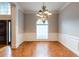 Spacious dining room with hardwood floors, chandelier, wainscoting, and large arched window for natural light at 185 Beracah Sw Walk, Atlanta, GA 30331