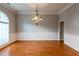 Spacious dining room with hardwood floors, chandelier, wainscoting, and large arched window for natural light at 185 Beracah Sw Walk, Atlanta, GA 30331