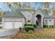 Charming brick home features an attached two-car garage, a stone portico and manicured landscaping at 185 Beracah Sw Walk, Atlanta, GA 30331