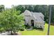 Angle view of a well-manicured front lawn and the home's brick facade with arched entryway at 185 Beracah Sw Walk, Atlanta, GA 30331