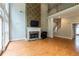 Open-concept living room featuring hardwood floors, a fireplace, a staircase and a high ceiling at 185 Beracah Sw Walk, Atlanta, GA 30331