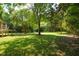 Expansive backyard featuring lush green grass and mature trees providing shade and privacy at 2116 Strasburg Ct, Atlanta, GA 30338