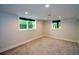Finished basement with neutral carpet and paint, recessed lighting, and two windows at 2116 Strasburg Ct, Atlanta, GA 30338