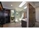 Modern bathroom featuring a glass enclosed shower, dual vanities, wood paneled wall, skylights, and a walk-in closet at 2116 Strasburg Ct, Atlanta, GA 30338