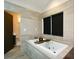 Bright bathroom featuring a soaking tub, neutral tile, and an open doorway at 2116 Strasburg Ct, Atlanta, GA 30338