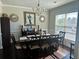 Elegant dining room with a dark wood table set for eight, a chandelier, and a large window with natural light at 3227 Puritan Way, Mcdonough, GA 30252