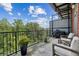 Relaxing balcony area offering a serene view of lush greenery, outdoor seating, and a grill at 5200 Peachtree Rd # 3420, Atlanta, GA 30341