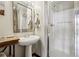 Well-lit bathroom with a pedestal sink, a framed mirror, and a clean walk-in shower at 5200 Peachtree Rd # 3420, Atlanta, GA 30341