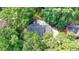 An aerial view shows the home's roof and the surrounding trees and lawn at 5285 Bannergate Dr, Johns Creek, GA 30022