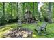 Backyard features a fire pit with Adirondack chairs near a custom treehouse at 5285 Bannergate Dr, Johns Creek, GA 30022