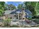 Back exterior view of the home featuring a brick exterior, stone chimney, a patio and a fenced yard at 5285 Bannergate Dr, Johns Creek, GA 30022