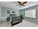 Bright bedroom with light blue walls, a ceiling fan, and a large window for ample natural light at 5285 Bannergate Dr, Johns Creek, GA 30022