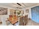 Stylish dining room featuring a wood table, woven chairs, a painted hutch and an elegant light fixture at 5285 Bannergate Dr, Johns Creek, GA 30022