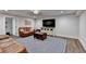 Basement living room with brown leather sofas, a TV, and a stylish rug and decorative accents at 5285 Bannergate Dr, Johns Creek, GA 30022