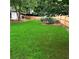 Spacious backyard with green lawn, mature trees, and wood fence bordering the property at 1003 River Plantation Dr, Woodstock, GA 30188