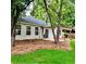 Landscaped backyard with covered patio and mature trees provides privacy and shade at 1003 River Plantation Dr, Woodstock, GA 30188