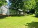 Large backyard featuring green lawn, mature trees, and the exterior of the home at 1003 River Plantation Dr, Woodstock, GA 30188