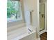 Well-lit bathroom featuring a soaking tub under a window and a glass-door shower at 1003 River Plantation Dr, Woodstock, GA 30188