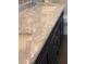 Close-up view of a bathroom vanity with white marble countertop, black cabinets, and chrome hardware at 1003 River Plantation Dr, Woodstock, GA 30188