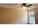 Bedroom featuring tan walls, a ceiling fan and a window with a tree-filled outdoor view at 1003 River Plantation Dr, Woodstock, GA 30188