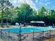 View of community pool area with playground, pool furniture and tables at 1003 River Plantation Dr, Woodstock, GA 30188