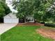 Charming single-Gathering home featuring a two-car garage and well-maintained front lawn at 1003 River Plantation Dr, Woodstock, GA 30188