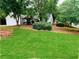 Inviting home with a lush green lawn, mature trees, and a side-entry garage at 1003 River Plantation Dr, Woodstock, GA 30188