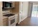 Bright kitchen with a stainless steel microwave and stove, complemented by light wood flooring at 1003 River Plantation Dr, Woodstock, GA 30188