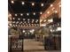 Outdoor restaurant area featuring string lights, brick facade and wrought iron railing and fencing at 1003 River Plantation Dr, Woodstock, GA 30188