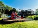 Community playground featuring a slide, benches, and shade by mature trees and tennis courts in the background at 1003 River Plantation Dr, Woodstock, GA 30188