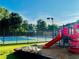 Community playground near a tennis court with benches, safety surface and a slide at 1003 River Plantation Dr, Woodstock, GA 30188
