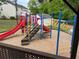 Community playground with a slide, climbing area, and soft landing surface for added safety at 1003 River Plantation Dr, Woodstock, GA 30188