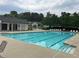 Community pool, surrounded by lounge chairs, with a pool house and ample space for recreation at 1003 River Plantation Dr, Woodstock, GA 30188
