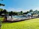 Community pool area featuring lounge chairs, umbrellas and a cabana, surrounded by a manicured lawn at 1003 River Plantation Dr, Woodstock, GA 30188