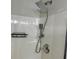 Close-up of a white shower with rain shower head, handheld sprayer, and corner shelf at 1003 River Plantation Dr, Woodstock, GA 30188