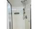 Modern shower with a rainfall showerhead, handheld sprayer, and built-in shelving at 1003 River Plantation Dr, Woodstock, GA 30188