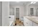 Well-lit bathroom featuring a double vanity, shower over tub, and tile floor, with a closet space at 1138 School Side Dr, Lithonia, GA 30058