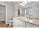 Bright bathroom with a double vanity, mirror, a toilet and a shower over tub at 1138 School Side Dr, Lithonia, GA 30058